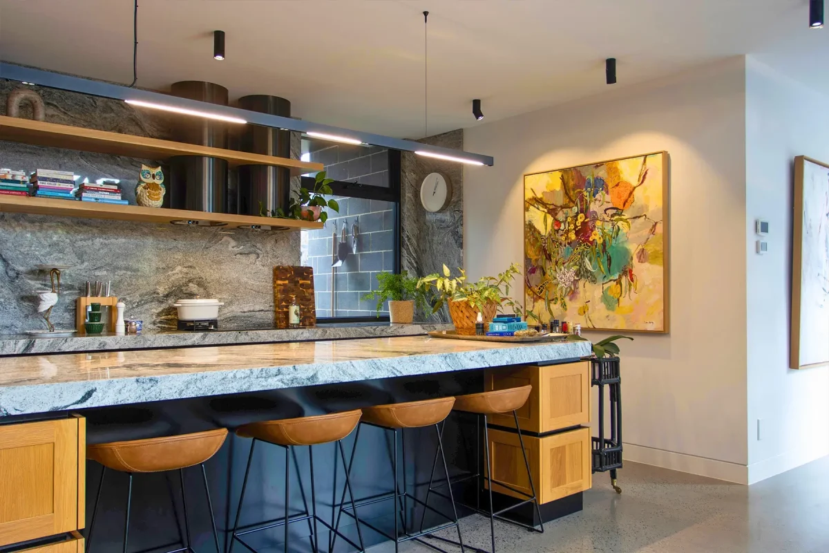 a kitchen with a marble counter top and wooden stools